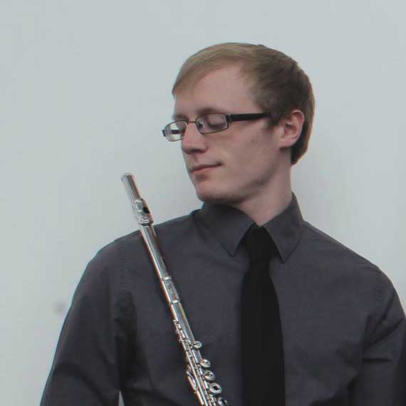 Trey Sims in gray shirt looking at flute