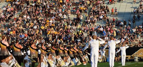 Three Drum Majors saluting and Color Guard on field during Pre-Game show. 